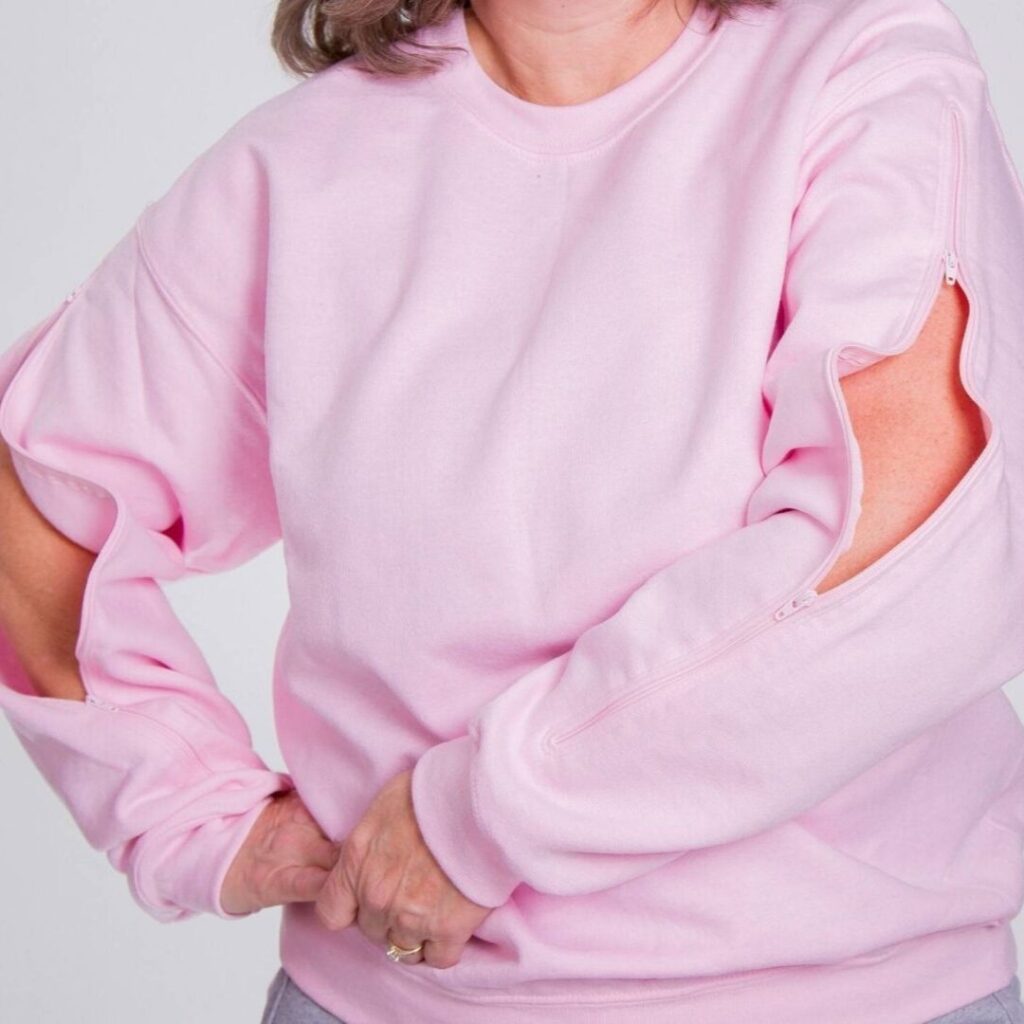 woman wearing pink sweatshirt with zippers on the sleeves